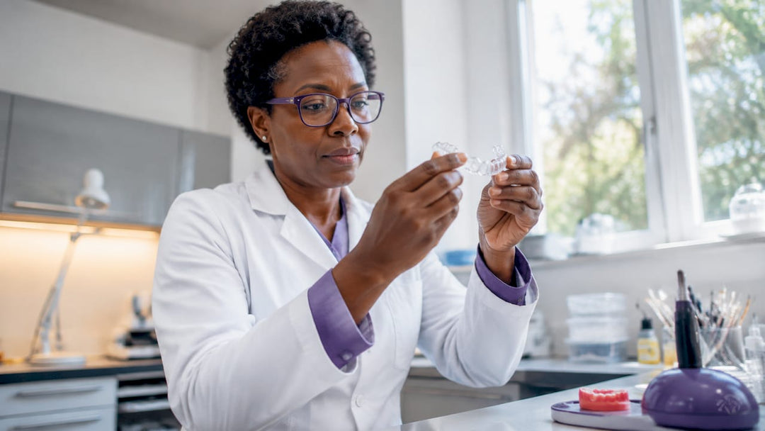 Dental technician inspecting clear retainer