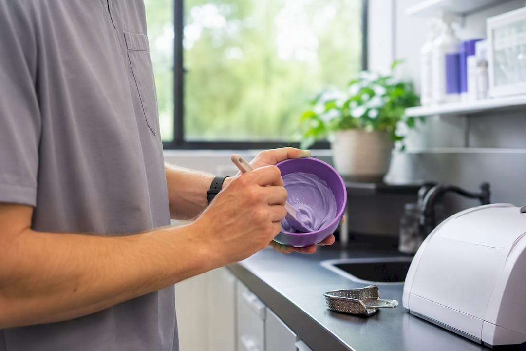 Hands filling dental impression tray