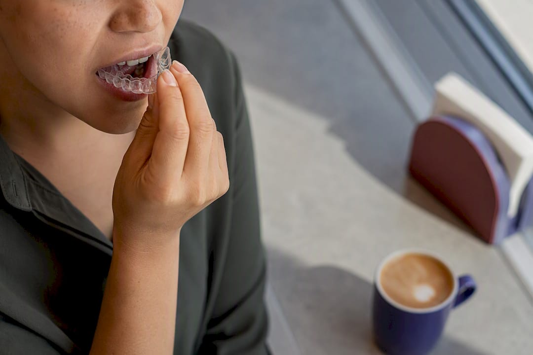 Person inserting mouth guard in bathroom