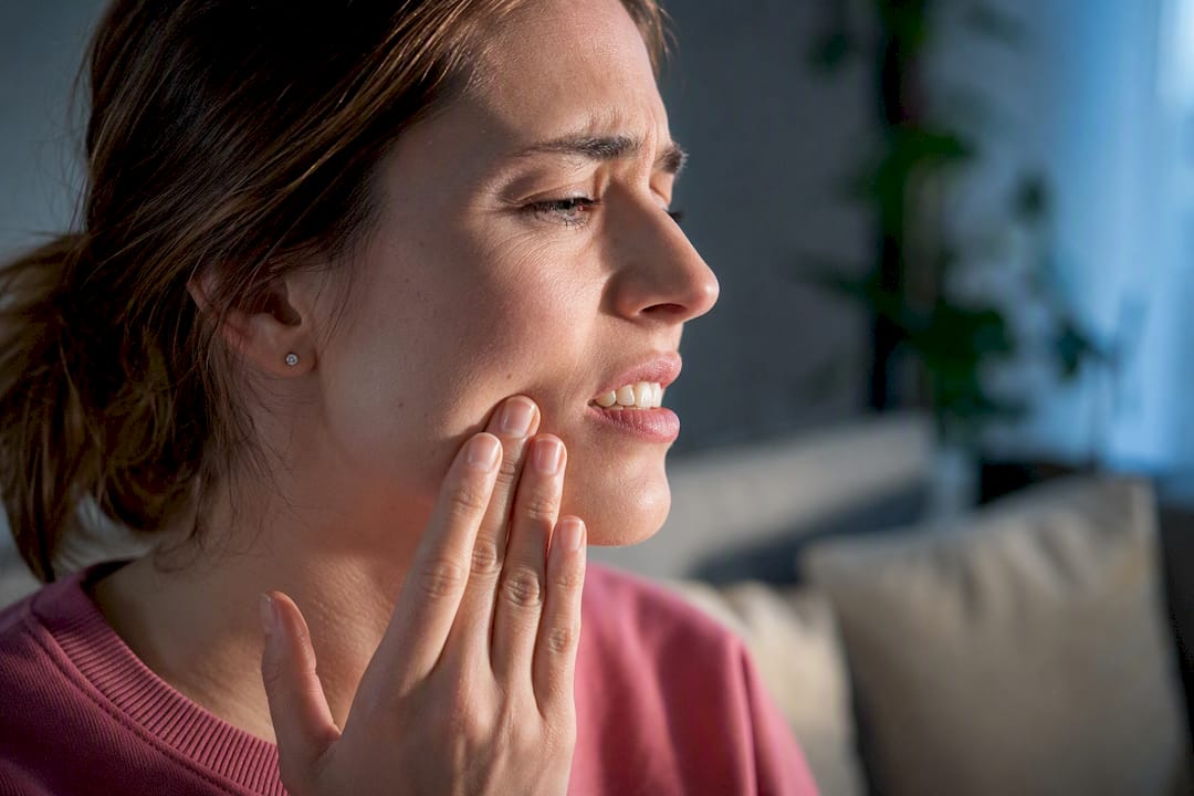 Adult reacting to tooth sensitivity after whitening