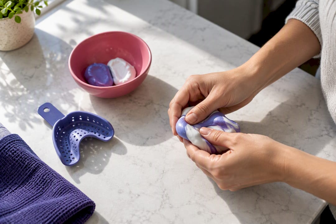 Hands preparing a home dental impression kit